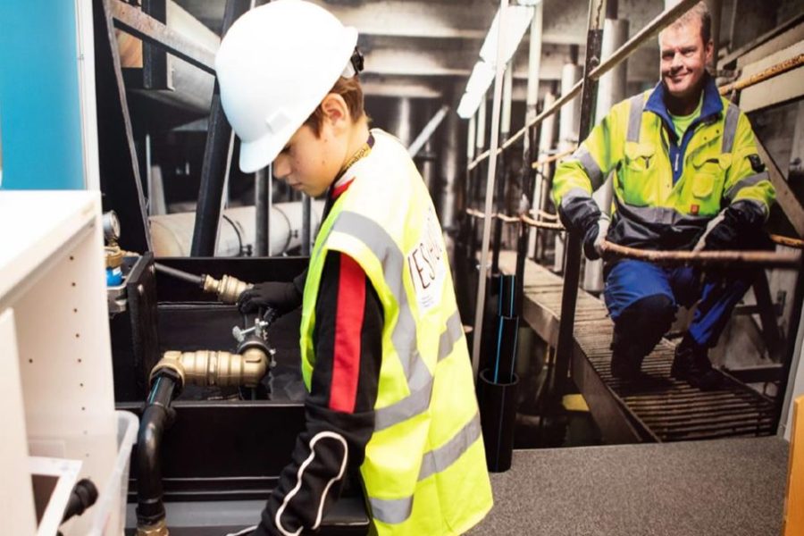 Vesihuollon pienoisyrityksen työntekijä korjaamassa putkea